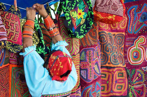 Panamanian woman hanging colorful textiles on a clothes line