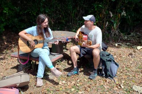 Intern playing guitar with our music teacher