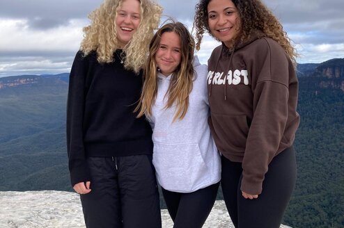 Three students on a mountaintop in Australia