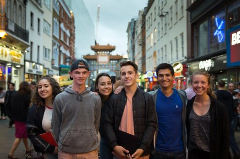 High school students stand on a street.
