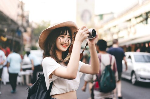 Woman traveling and holding up camera to take photos