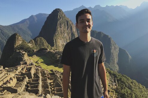 A man stands in front of Machu Picchu.