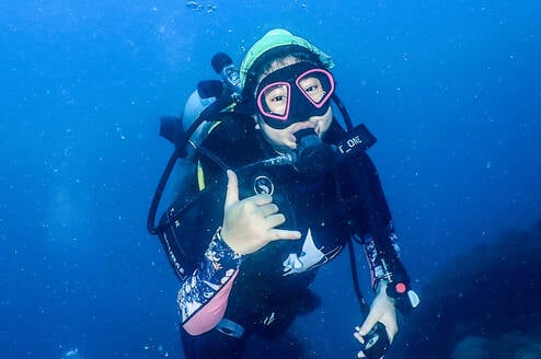 Student is scuba diving and giving a thumbs up