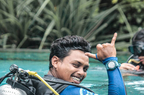 Dive instructor in a swimming pool giving the "that rocks" signal