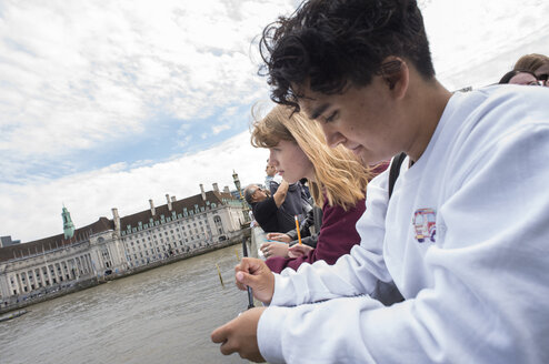 Students leaning on bridge