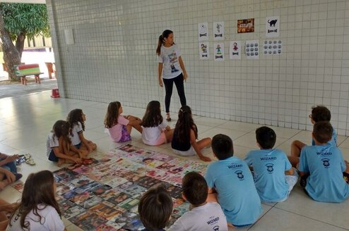 A teacher stands in front of a class of young children.