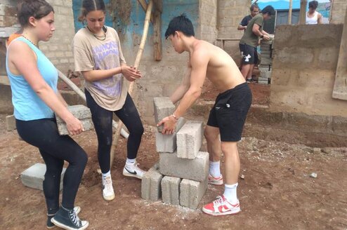 Construction volunteers arrainging bricks