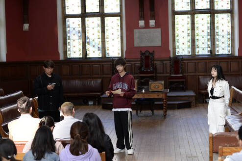 Three students presenting in the Oxford Union