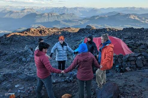 Crew circles up on a rocky summit