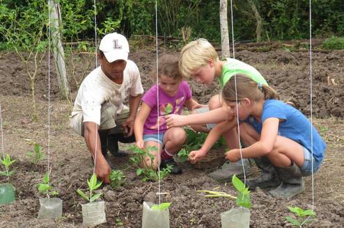 woman taking care of a vegetable garden with 3 children