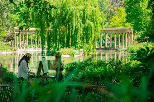 Two artists painting on easels in a garden in Paris