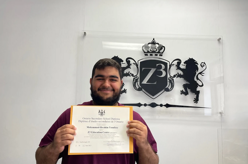 A graduating high school student holding a OSSD diploma from Z3 Education Centre