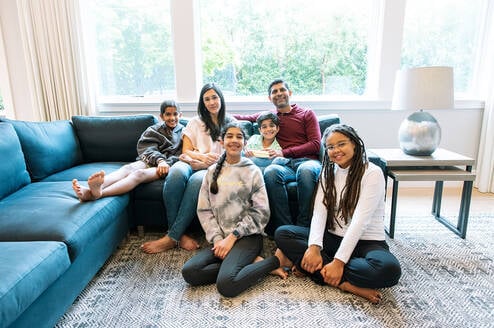Au pair sitting with host family in the living room