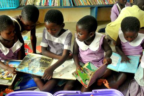 Children enjoying reading and literacy games at GHEI's community library in Humjibre