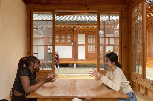 Gap year students in Seoul chatting at table