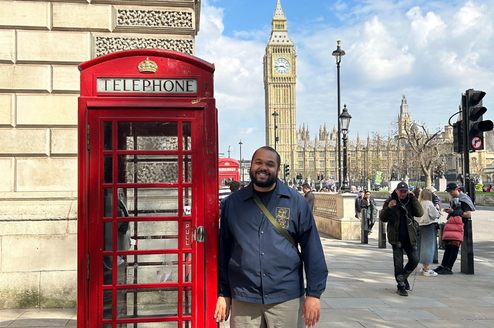 Man standing beside a British red telephone box