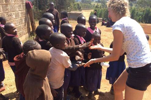 Volunteer celebrating with school children 