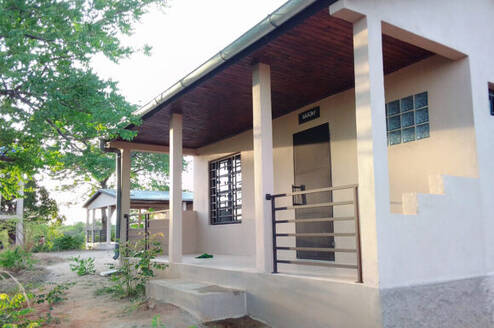A white stucco porch facing a tamarind tree