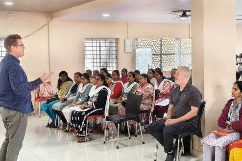 A room of students attending a course, watching the trainer. 