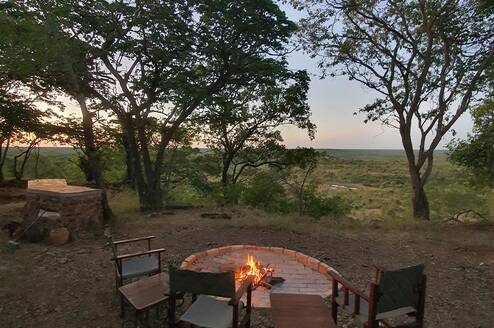 Camp fire and chairs in the bush