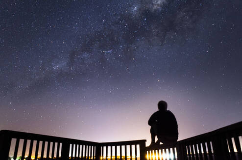 Student poses beneath star filled sky.