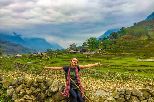 Student standing in front of rice fields