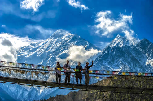 Students pose on bridge in Himalayas.