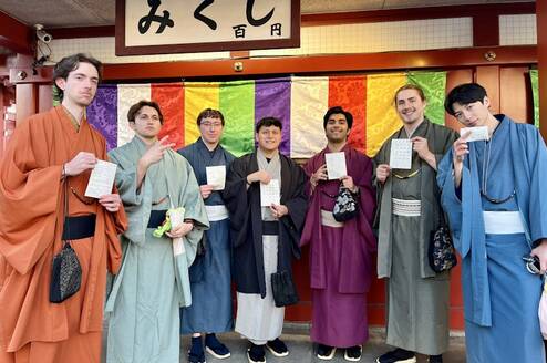 Group of students in kimonos in front of a colorful wall
