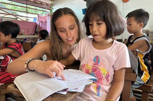 Volunteer teacher helping student 