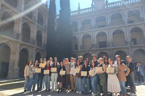 Students with certificates at historic university campus 