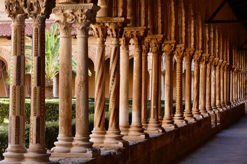 Row of decorated medieval columns in the Monreale Cathedral cloister, Sicily