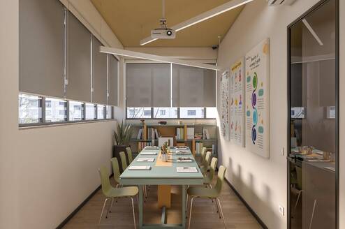 The classroom is used for both online and in-person courses and has a maximum capacity of 10 students. It includes a study library with teaching materials, a projector, a writing board, and visual learning aids displayed on the walls.