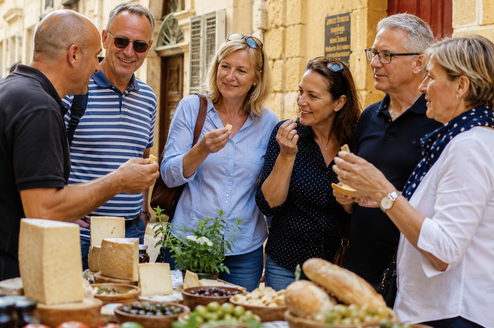 Mature students attending a food tour in Valetta, Malta. Trying food from the market.
