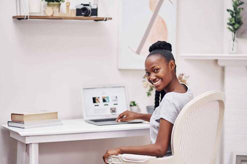 Woman using a laptop at a desk at home