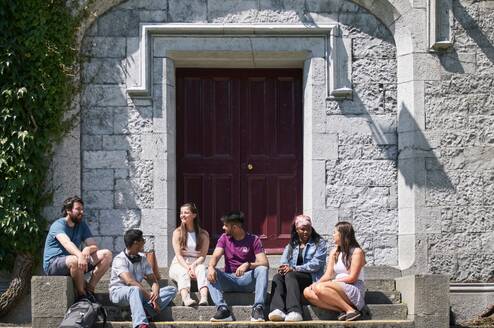 Students sitting at the quadrangle door entrance 