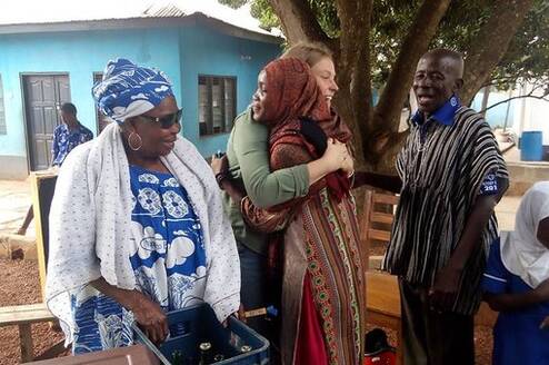 Volunteer hugging local child