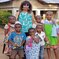 Our volunteer posing with some children from a children's home after donating hand made clothes from our sawing project