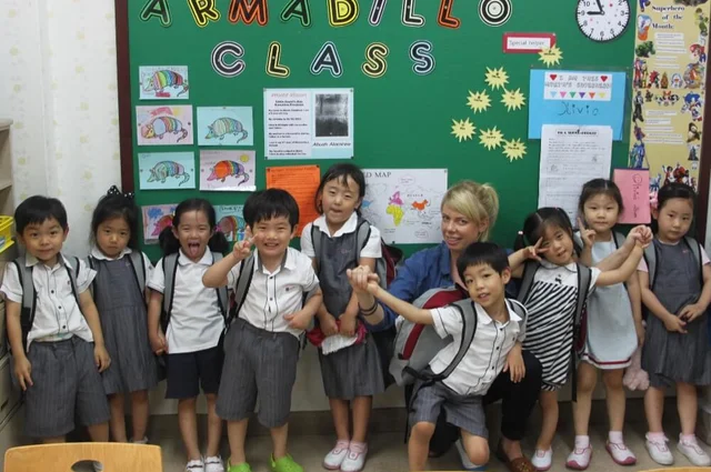 group of children in uniforms in front of board