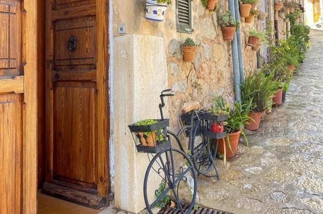 A quaint alleyway featuring a vintage bicycle leaning against a weathered door, capturing the essence of Spain and RVF International’s teach abroad adventure.