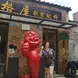Young woman posing with statue in China
