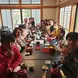 a large group of people sitting around a table in a traditional Japanese restaurant