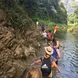a group of hikers wade through a river in a jungle