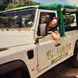 A smiling woman peering through the window of a Jeep