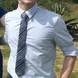 a young man wearing dress apparel and sunglasses