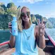 Caroline posing on a boat giving a peace sign