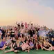 A group of travelers posing in front of a sunset