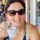 Onora Gill-Fitch holding an espresso and smiling while wearing sunglasses