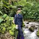 Vanessa Rees standing in a stream in a jungle with a hat on smiling
