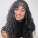 Brianna Dora Costa with curly black hair and brown eyes smiling