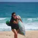 Débora Newlands Souza carrying a bag of trash she picked up off a beach